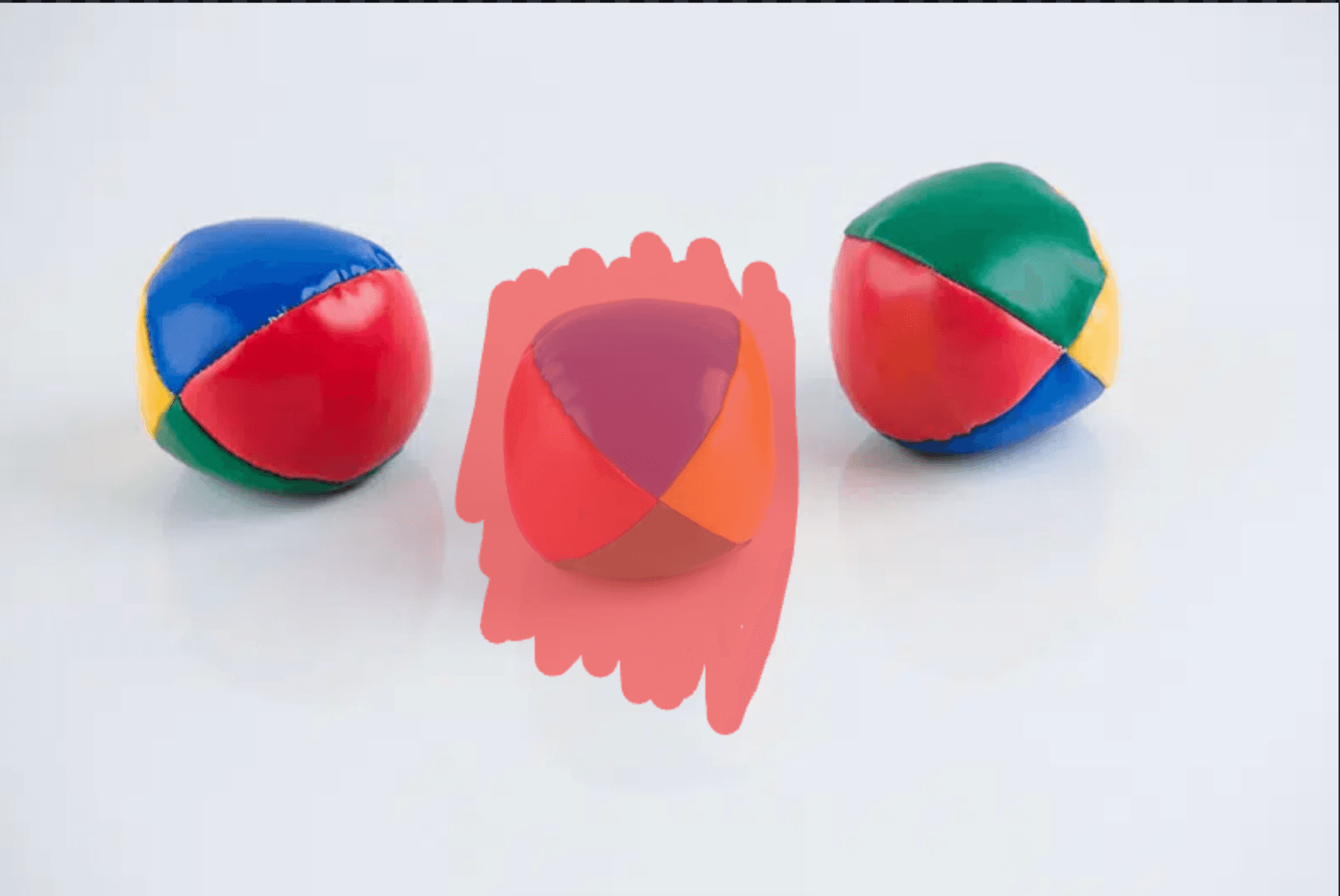 Three juggling balls — middle one painted over for removal
